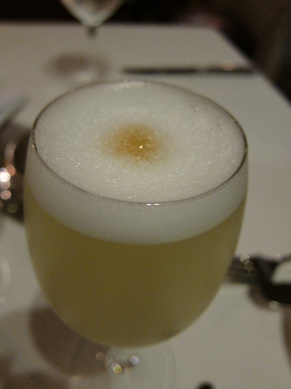 IMG_1905.JPG - The classic Peruvian drink - Pisco Sour, made with Peruvian pisco (grape brandy), lime juice, syrup, ice, egg white, and Angostura bitters.  This is from El Tupay restaurant.